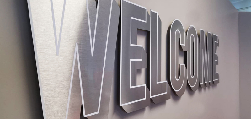 vue diagonale d'un lettrage aluminium mural avec liseré blanc du mot Welcome