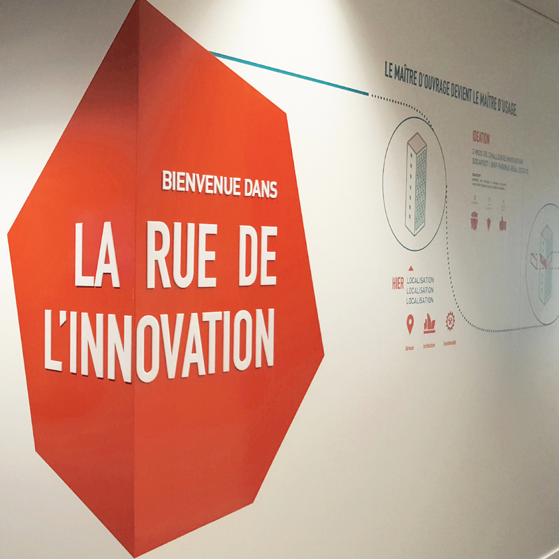 Décoration murale et signalétique d'entreprise sur fond orange d'un logo en relief blanc